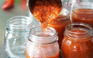 Pouring Hot Homemade Tomato Relish Into Jars